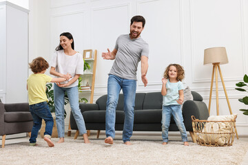 Poster - Happy family dancing and having fun in living room, low angle view