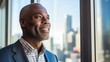 optimistic black businessman executive CEO in corporate modern office thinking contemplating and looking out window skyscraper cityscape daytime 