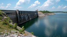 A Massive Concrete Dam Towers Over A Calm Lake Its Walls Fortified To Withstand The Strong Winds That May Come Its Way.