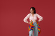 © Pixel-Shot - Young African-American woman with rainbow flags on red background. LGBT concept