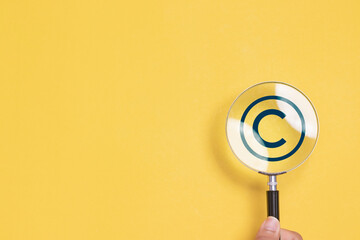 Copyright or patent concept. Magnifying glass focus to copyright symbol for author rights and patented intellectual property. copyleft trademark license.