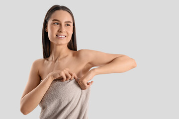 Poster - Beautiful woman in towel after shower on light background