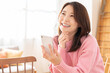 © miya227 - 部屋でスマホを見る若い女性