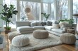 A spacious, snowy view through large windows complementing a modern white sofa and soft pouffes in a clean living room.