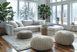 Fototapeta  - A spacious, snowy view through large windows complementing a modern white sofa and soft pouffes in a clean living room.