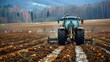 A tractor is used to plow fields, which involves getting the land ready for planting.