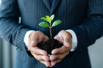 Man in a suit holding a small plant in his hands