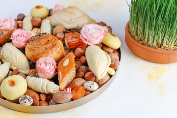 Sticker - Traditional Azerbaijan holiday Novruz background with green semeni,traditional azerbaijan sweets,shekerbura,qogal,paxlava,mutaki and different nuts and sweets,top view,space for copy