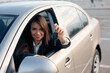 Smiling young business woman holding car keys. Concept of buying car.