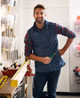 © ArcursJointTeam/peopleimages.com - Portrait, wood and carpenter man with diy tools for home development, woodwork and building renovation. Smiling, male employee and contractor for maintenance, equipment and repair work in garage