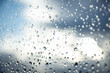 Kontrast der Elemente: Regentropfen an der Fensterscheibe vor sonnendurchflutetem Himmel