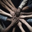 © video rost - Overhead view of diverse hands joined together in a show of unity and collaboration. The image captures the essence of teamwork and mutual support in a dark, moody setting.