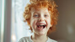 Joyful child with curly red hair laughs heartily