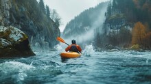 An Adventurer In An Orange Kayak Braves The Choppy, Spray-filled Rapids Of A Mountain River, With Misty Mountains Looming In The Background