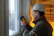 © ChaoticMind - A professional building inspector uses a device to check for proper window insulation in a home