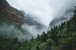A mountain shrouded in fog and clouds towers next to a dense forest, creating a mystical and atmospheric scene
