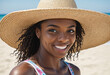 Portrait of stylish black woman in a straw hat on the sandy beach on vacation, full of joy