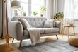 a living room interior that exudes warmth with its cozy grey sofa, an armchair, glowing lamps, and tasteful decorative elements, providing a homely and serene space