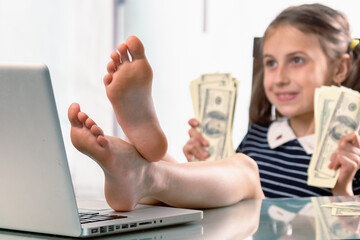 Cheerful young happy business girl counts profits, took off her shoes and working in office with bare feet. Selective focus.  Horizontal image.