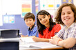© Austockphoto - Public school students sitting at their desk smiling