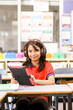 © Austockphoto - Female student girl with her headphones on using an iPad in the classroom