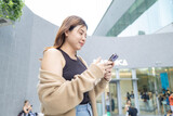 Fototapeta Desenie - Business asian woman casual use smartphone city building communication happy enjoy business woman