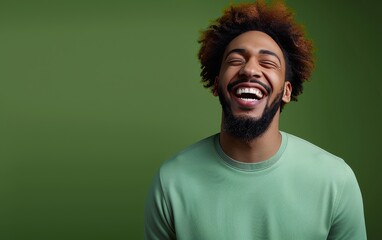 A man with a beard and a green shirt is smiling and laughing