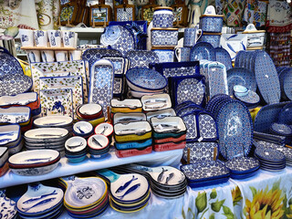 Collection of colorful Portuguese ceramic pottery counter, local craft products from Portugal. Ceramic plates display in Portugal.