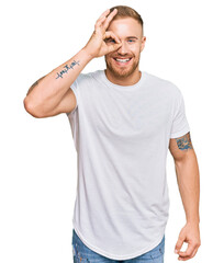 Wall Mural - Young irish man wearing casual clothes doing ok gesture with hand smiling, eye looking through fingers with happy face.