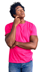 Poster - Handsome african american man with afro hair wearing casual pink tshirt serious face thinking about question with hand on chin, thoughtful about confusing idea