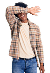 Canvas Print - Handsome african american man with afro hair wearing casual clothes and glasses covering eyes with arm smiling cheerful and funny. blind concept.