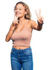 Wall Mural - Beautiful caucasian woman wearing casual clothes smiling looking to the camera showing fingers doing victory sign. number two.