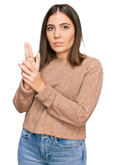 Canvas Print - Young beautiful woman wearing casual clothes holding symbolic gun with hand gesture, playing killing shooting weapons, angry face