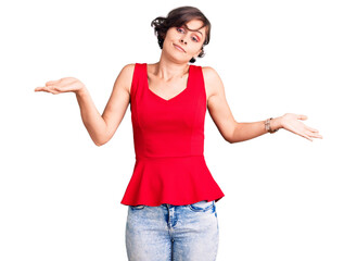 Canvas Print - Beautiful young woman with short hair wearing casual style with sleeveless shirt clueless and confused expression with arms and hands raised. doubt concept.