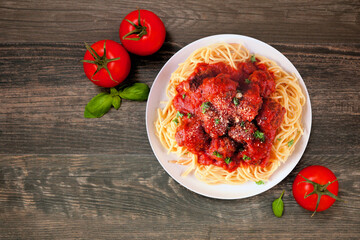 Canvas Print - Homemade spaghetti and meatballs with tomato sauce. Above view table scene on a dark wood background.