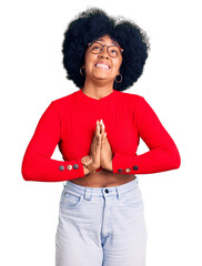 Canvas Print - Young african american girl wearing casual clothes and glasses begging and praying with hands together with hope expression on face very emotional and worried. begging.