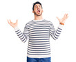 Young hispanic man wearing casual clothes crazy and mad shouting and yelling with aggressive expression and arms raised. frustration concept.