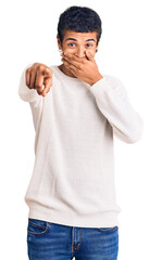 Canvas Print - Young african amercian man wearing casual clothes laughing at you, pointing finger to the camera with hand over mouth, shame expression