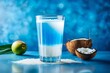 Organic milky coconut sparkling juice poured out in glass, blue background