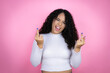 African american woman wearing casual sweater over pink background showing middle finger doing fuck you bad expression, provocation and rude attitude. screaming excited