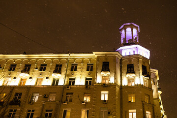 Poster - illuminated apartment building on Kadashevskaya embankment in snowfall in Moscow city on winter night