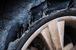Flat and torn front left tire of the car in close-up
