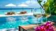 White wine in glasses with the pool and sandy beach and ocean in the background