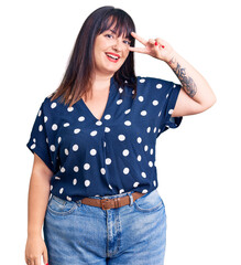 Poster - Young plus size woman wearing casual clothes doing peace symbol with fingers over face, smiling cheerful showing victory