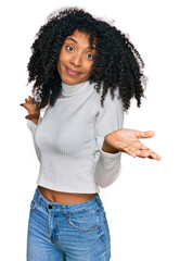 Wall Mural - Young african american girl wearing casual clothes clueless and confused expression with arms and hands raised. doubt concept.