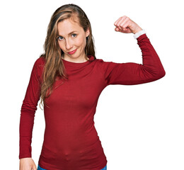 Wall Mural - Young blonde woman wearing casual clothes strong person showing arm muscle, confident and proud of power