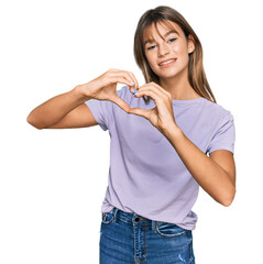 Wall Mural - Teenager caucasian girl wearing casual clothes smiling in love doing heart symbol shape with hands. romantic concept.