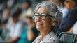 Beautiful senior woman in the stands of a stadium during a sporting event.