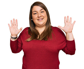 Wall Mural - Beautiful brunette plus size woman wearing casual clothes showing and pointing up with fingers number ten while smiling confident and happy.