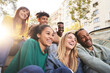 © CarlosBarquero - Happy smiling multi-ethnic group friends having fun together. Multiracial diverse young colleagues embracing posing for selfie photo on street in city. Multicultural friendship generation Z concept.